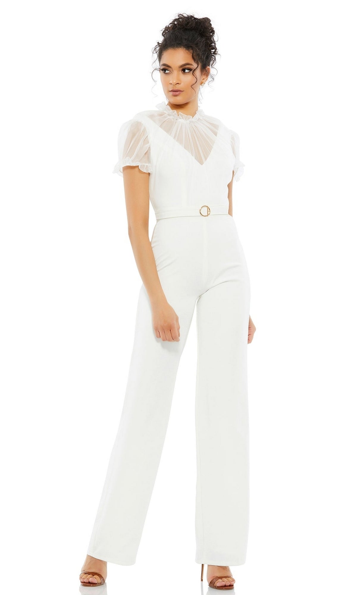 Woman wearing the Long Formal Jumpsuit 26621 by Mac Duggal with a high neck, sheer short sleeves, belted waist, and nude heeled sandals, standing against a plain white background.